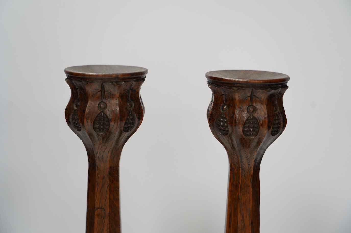 A pair of Arts and Crafts carved oak candlesticks, 28cm. Condition - good